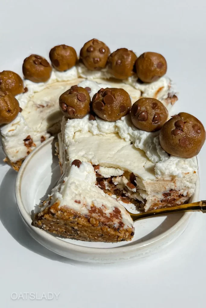 showing a showing a forkful of a no bake cheesecake with cookie dough slice and the complete cheesecake